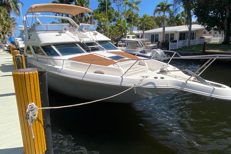 Slide: The Image of 1994 Sea Ray 440 Express Bridge yacht docked by palm trees. - 10