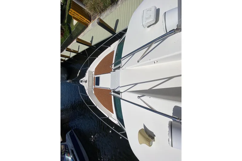 Slide: The Image of Overhead view of 1994 Sea Ray 440 Express Bridge yacht docked by a wooden pier. - 12
