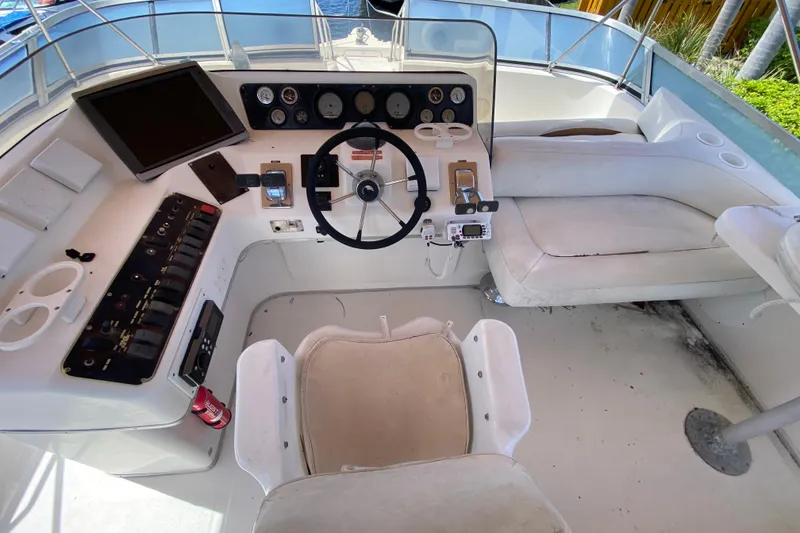 Slide: The Image of Cockpit of 1994 Sea Ray 440 Express Bridge with steering wheel and control panel. - 18