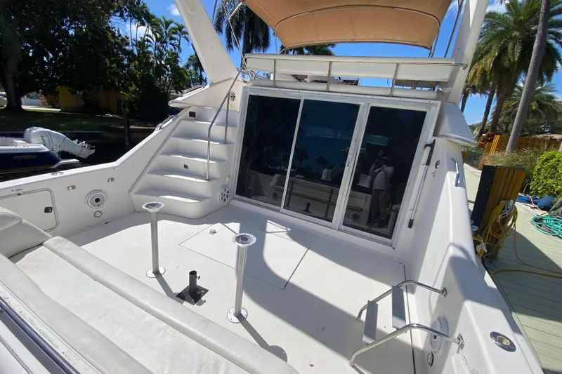 Slide: The Image of 1994 Sea Ray 440 Express Bridge yacht deck with stairs and sliding glass doors. - 21