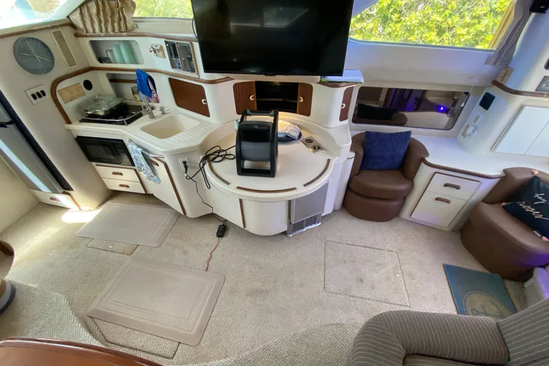 Slide: The Image of Interior of 1994 Sea Ray 440 Express Bridge with kitchen and seating area. - 25