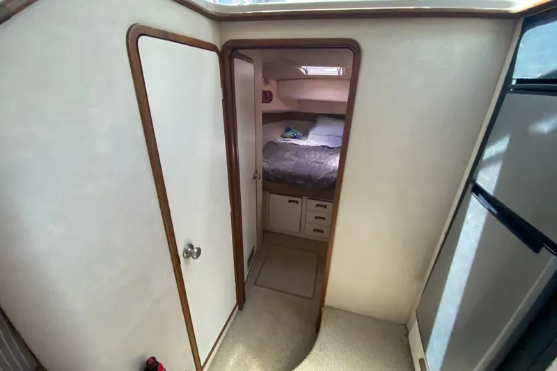 Slide: The Image of 1994 Sea Ray 440 Express Bridge cabin interior with bed and storage drawers. - 28