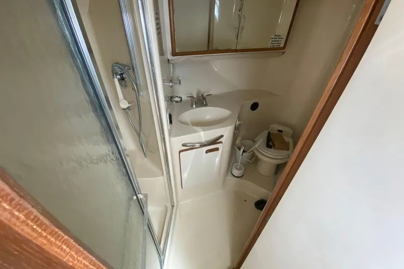 Slide: The Image of Bathroom interior of 1994 Sea Ray 440 Express Bridge yacht, featuring shower and sink. - 30