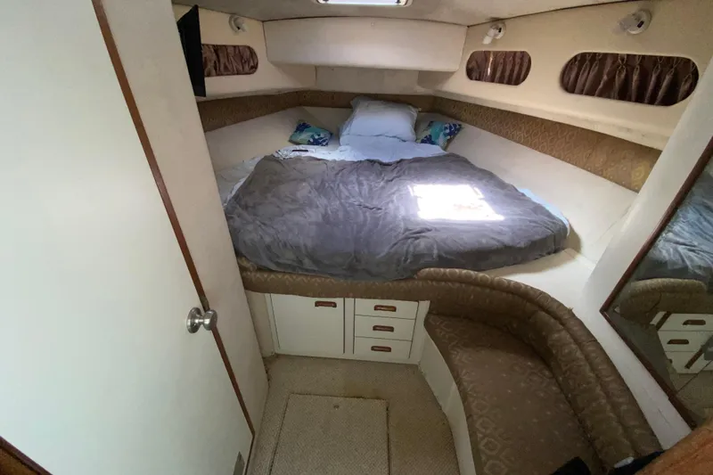 Slide: The Image of 1994 Sea Ray 440 Express Bridge cabin interior with bed, storage, and seating. - 32