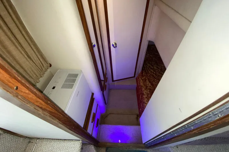 Slide: The Image of Interior view of 1994 Sea Ray 440 Express Bridge with stairs and ambient lighting. - 34