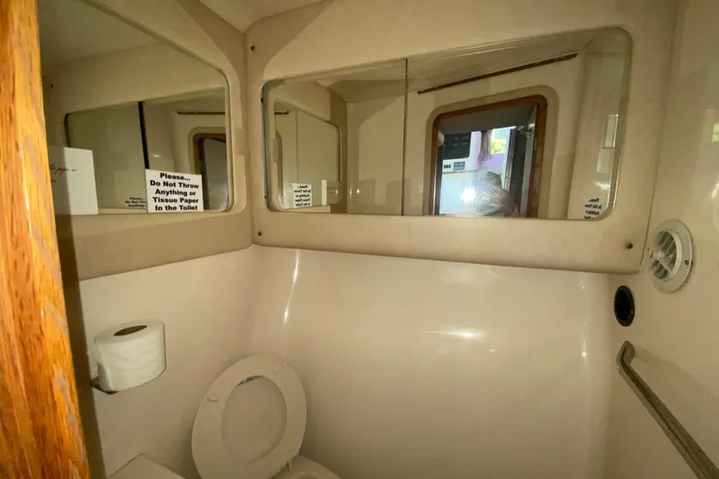 Slide: The Image of Bathroom interior of 1994 Sea Ray 440 Express Bridge with mirrors and toilet paper. - 35