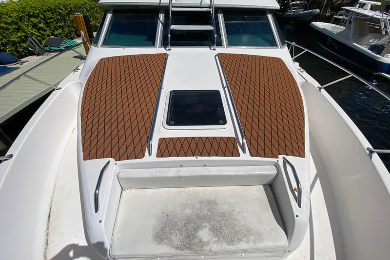 Slide: The Image of 1994 Sea Ray 440 Express Bridge boat deck with brown diamond-patterned mats. - 5