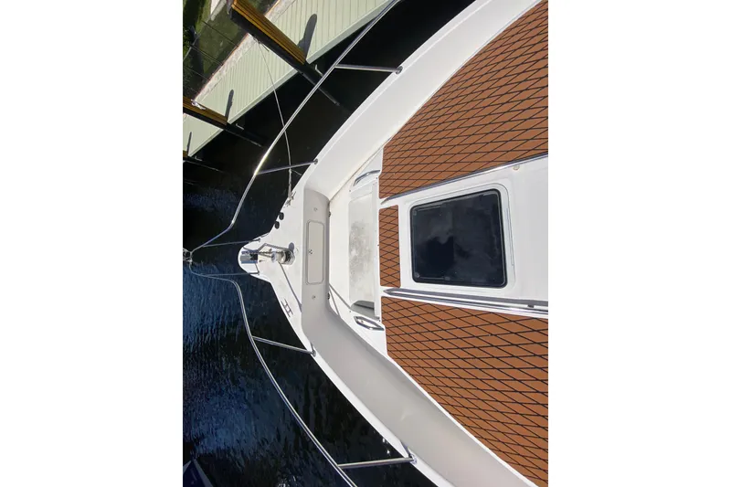 Slide: The Image of 1994 Sea Ray 440 Express Bridge yacht deck with teak flooring, docked by water. - 8