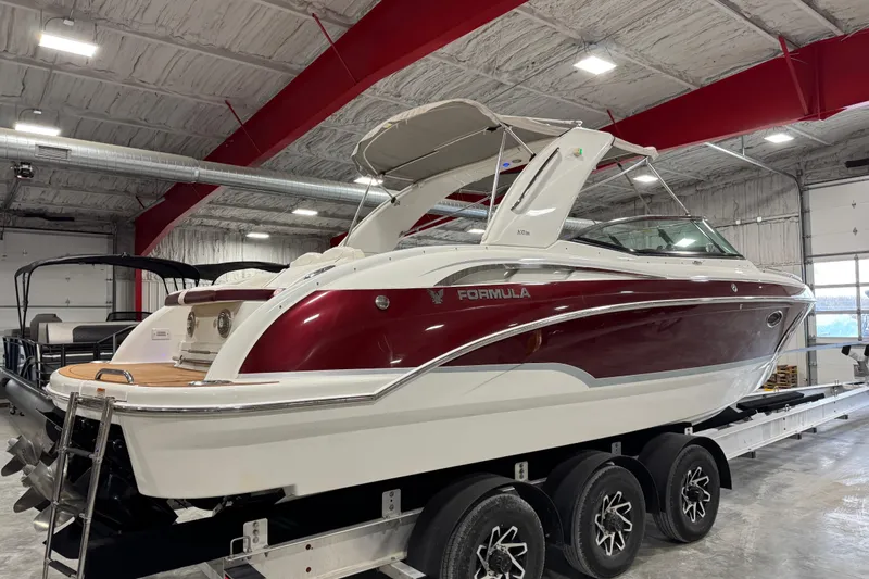 Slide: The Image of 2009 Formula 310 Bowrider boat in a garage, featuring a sleek red and white design. - 3