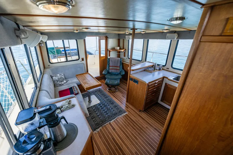 Slide: The Image of Interior of a 1997 Nordic Tug 42, featuring cozy seating and wooden cabinetry. - 10