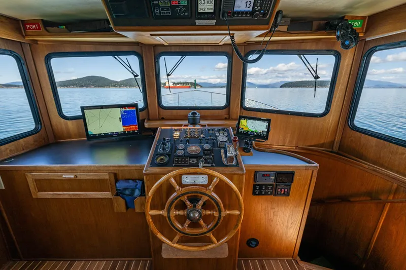 Slide: The Image of Pilothouse of a 1997 Nordic Tug 42 with navigation equipment and scenic water views. - 13