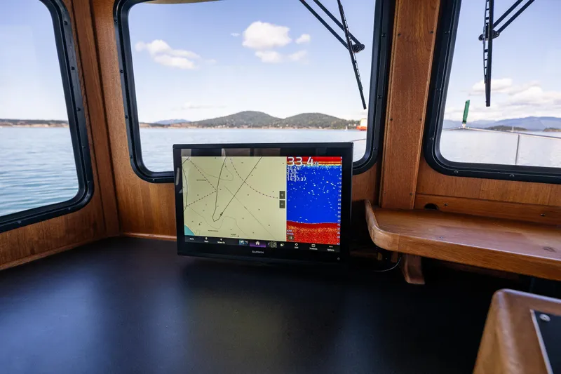 Slide: The Image of Navigation system inside 1997 Nordic Tug 42, with scenic water and mountain views. - 14
