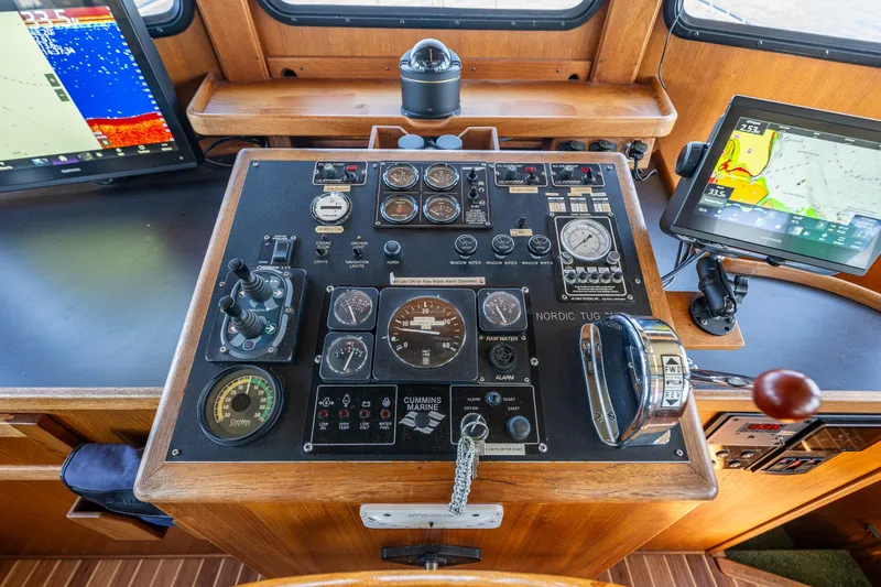 Slide: The Image of Control panel of a 1997 Nordic Tug 42 with navigation screens and gauges. - 15