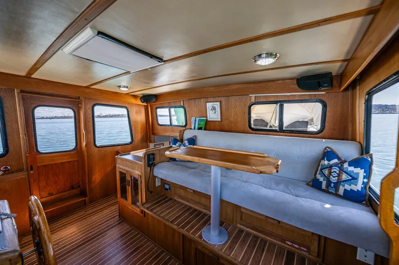 Slide: The Image of Interior of a 1997 Nordic Tug 42 with wooden paneling and cushioned seating. - 16