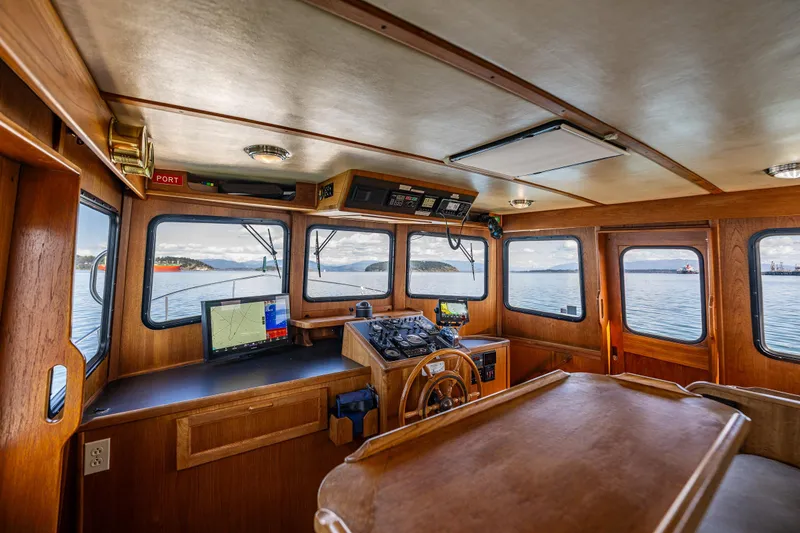 Slide: The Image of Pilothouse interior of a 1997 Nordic Tug 42, featuring navigation equipment and panoramic windows. - 17