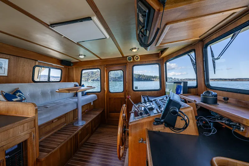 Slide: The Image of Interior of a 1997 Nordic Tug 42, featuring a cozy seating area and navigation controls. - 18