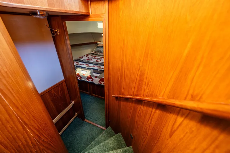 Slide: The Image of Interior of 1997 Nordic Tug 42, featuring wooden stairs leading to a cozy bedroom. - 20