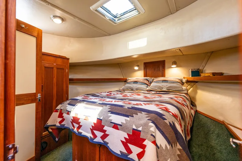 Slide: The Image of Cozy cabin interior of a 1997 Nordic Tug 42 with patterned bedding and wooden accents. - 21