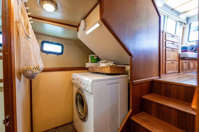 Slide: The Image of Laundry area inside a 1997 Nordic Tug 42 boat with wooden interior. - 24