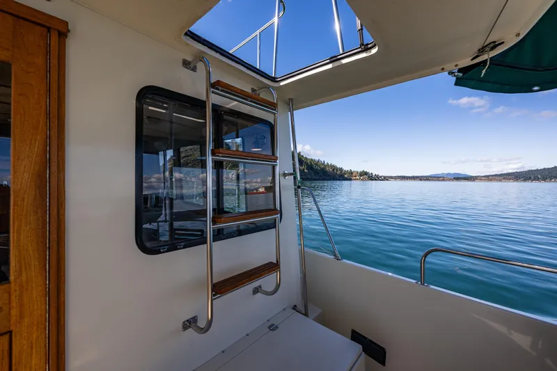 Slide: The Image of Nordic Tug 42 (1997) interior view with ladder, overlooking serene lake and distant hills. - 28