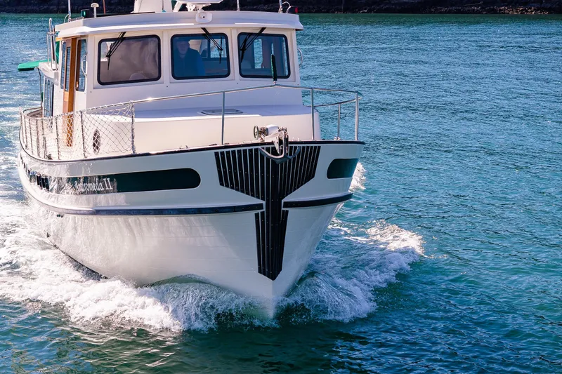 Slide: The Image of 1997 Nordic Tug 42 cruising on clear blue water. - 3