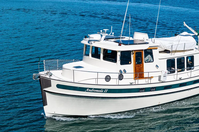 Slide: The Image of Nordic Tug 42 boat from 1997 cruising on blue water, named "Andromeda II". - 48