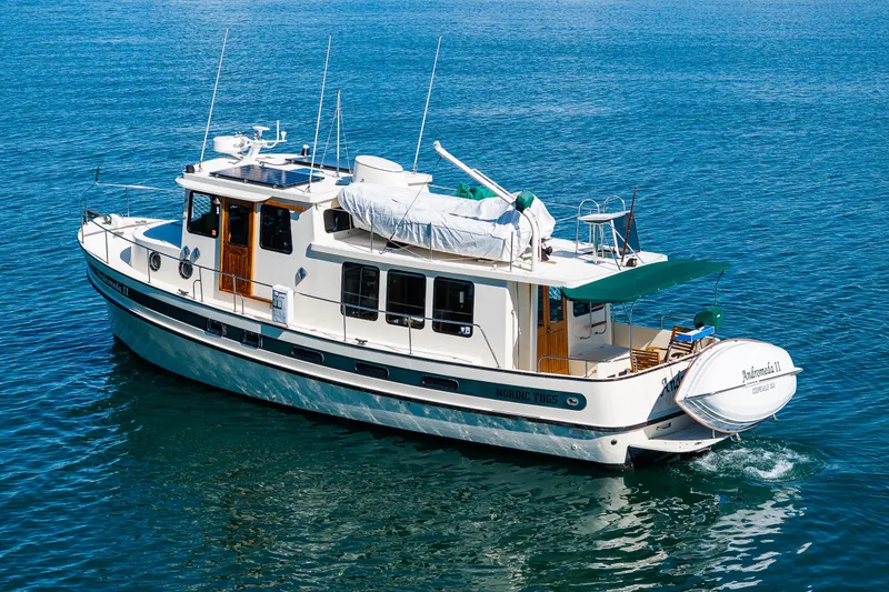 Slide: The Image of 1997 Nordic Tug 42 cruising on clear blue water, showcasing classic design and elegance. - 54