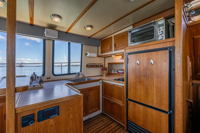 Slide: The Image of Cozy kitchen interior of 1997 Nordic Tug 42 with wooden cabinetry and ocean view. - 6
