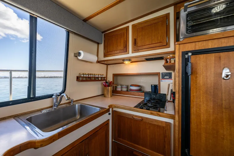 Slide: The Image of Cozy kitchen interior of 1997 Nordic Tug 42 with wooden cabinets and ocean view. - 8