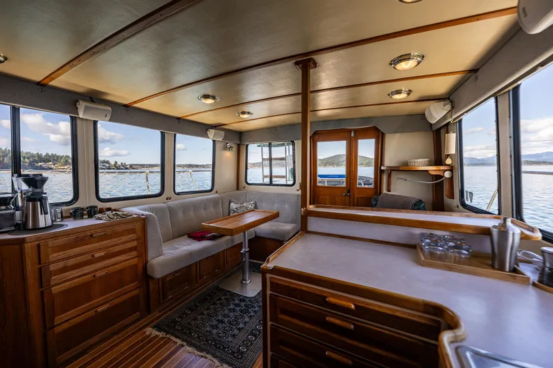 Slide: The Image of Interior of a 1997 Nordic Tug 42, featuring wood cabinetry and panoramic windows. - 9