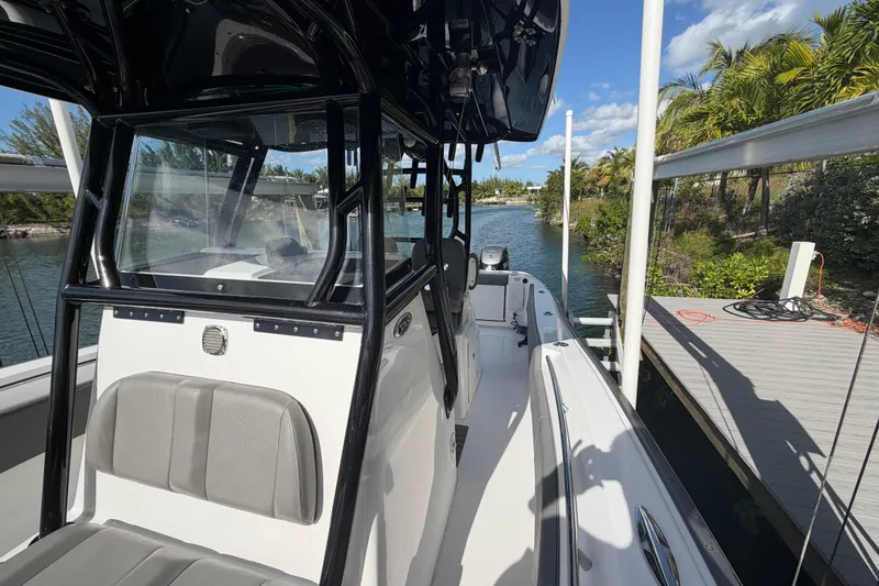 Slide: The Image of 2023 Cape Horn 32 XS boat docked by a scenic waterway with lush greenery. - 10