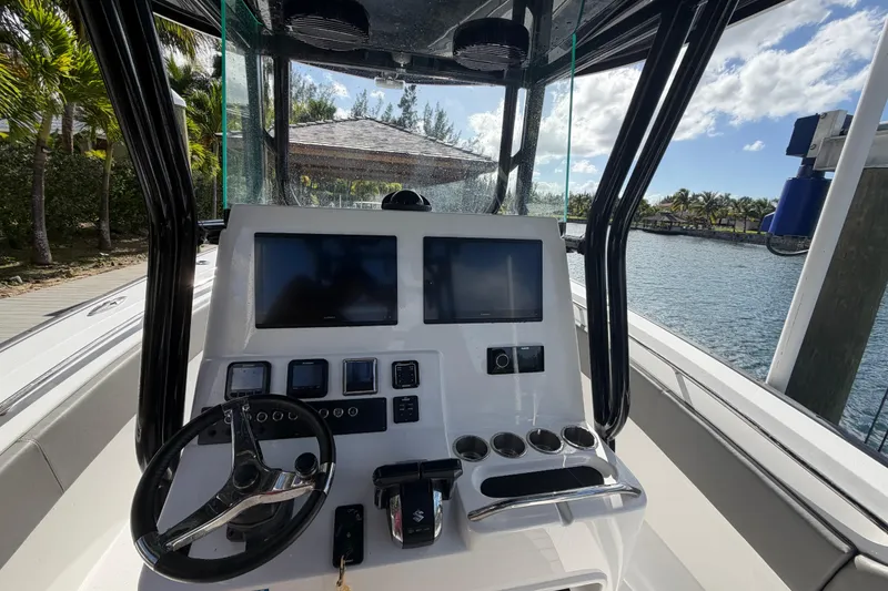 Slide: The Image of 2023 Cape Horn 32 XS boat dashboard with dual screens and steering wheel. - 16