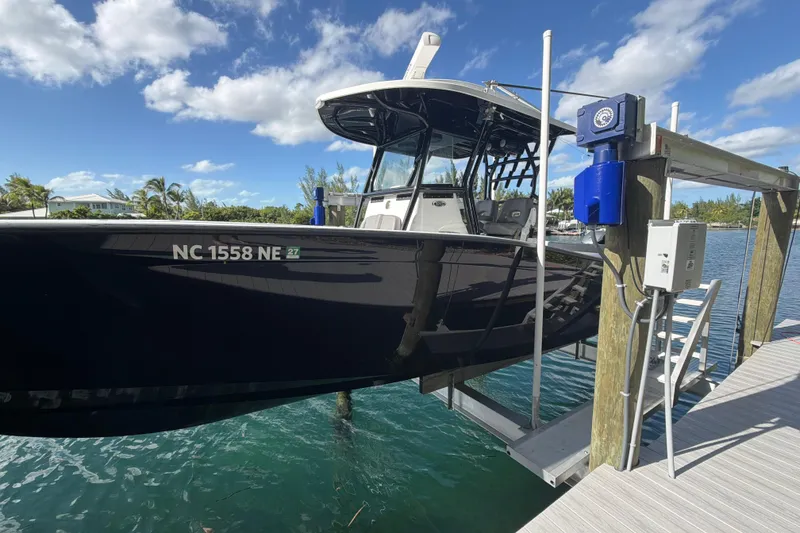 Slide: The Image of 2023 Cape Horn 32 XS boat docked, featuring sleek black design under a clear blue sky. - 4