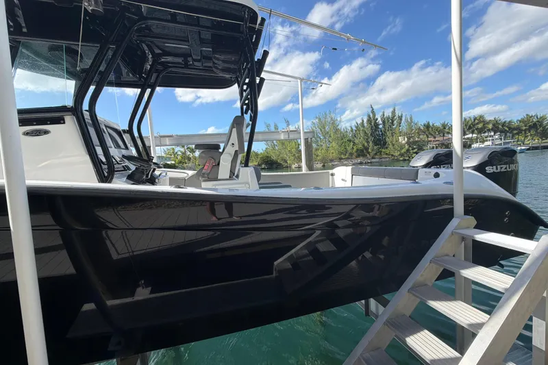 Slide: The Image of 2023 Cape Horn 32 XS boat docked, featuring sleek black hull and Suzuki engines. - 5