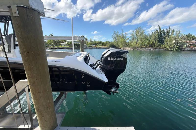 Slide: The Image of 2023 Cape Horn 32 XS boat with Suzuki outboard motor on a serene waterway. - 6