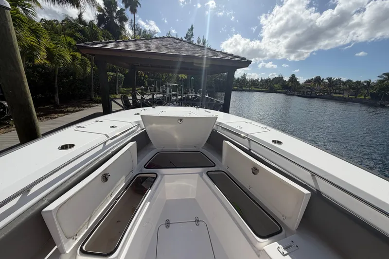 Slide: The Image of 2023 Cape Horn 32 XS boat with open storage compartments, docked by a scenic waterfront. - 8