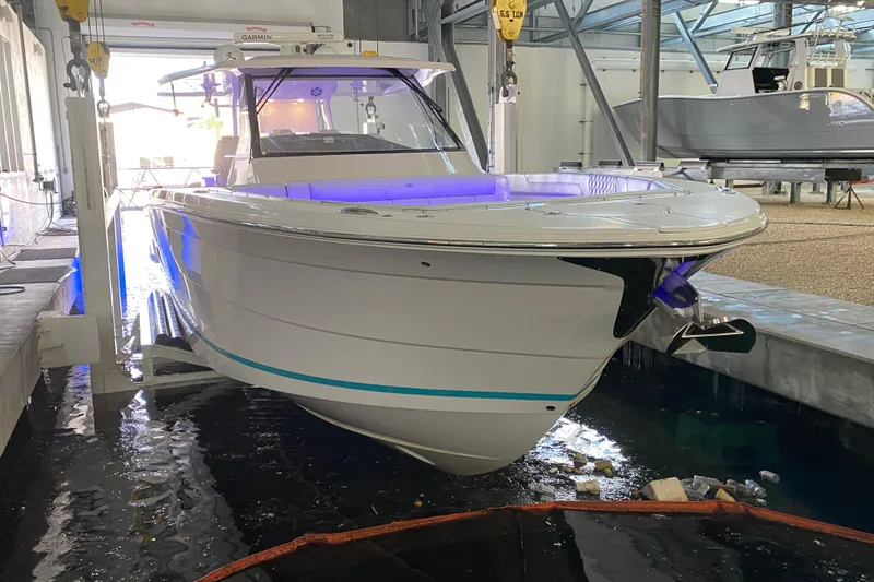 Slide: The Image of 2021 Regal 38 SAV boat in a marina, illuminated with blue lights. - 12