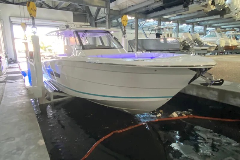 Slide: The Image of 2021 Regal 38 SAV boat in indoor storage, illuminated with blue lights. - 13