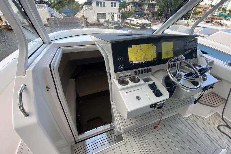 Slide: The Image of 2021 Regal 38 SAV boat cockpit with navigation screens and steering wheel. - 20