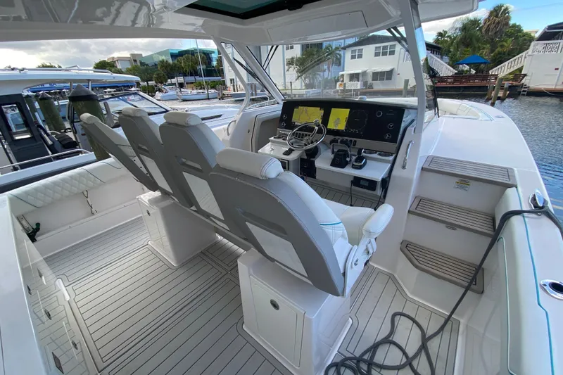 Slide: The Image of 2021 Regal 38 SAV boat interior with modern helm and seating, docked at marina. - 30