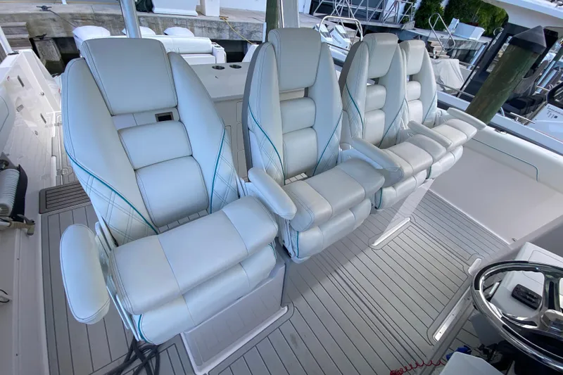 Slide: The Image of Luxury seating on 2021 Regal 38 SAV boat, featuring plush white captain chairs. - 32