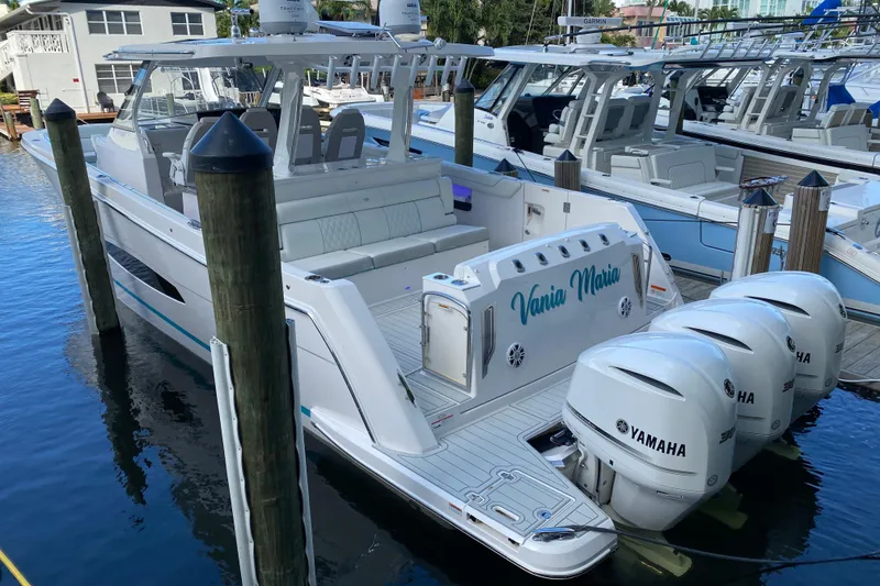 Slide: The Image of 2021 Regal 38 SAV boat docked with triple Yamaha engines. - 41
