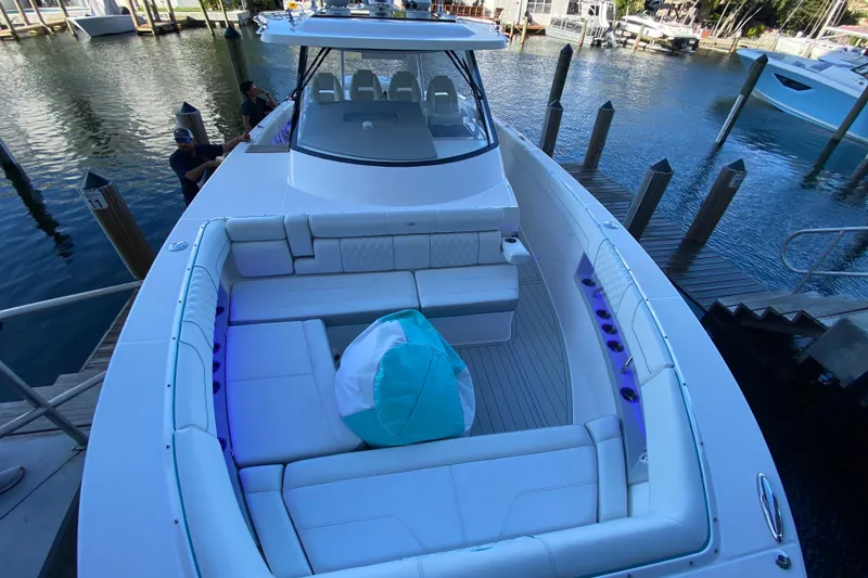 Slide: The Image of 2021 Regal 38 SAV luxury boat with spacious seating at a marina dock. - 5