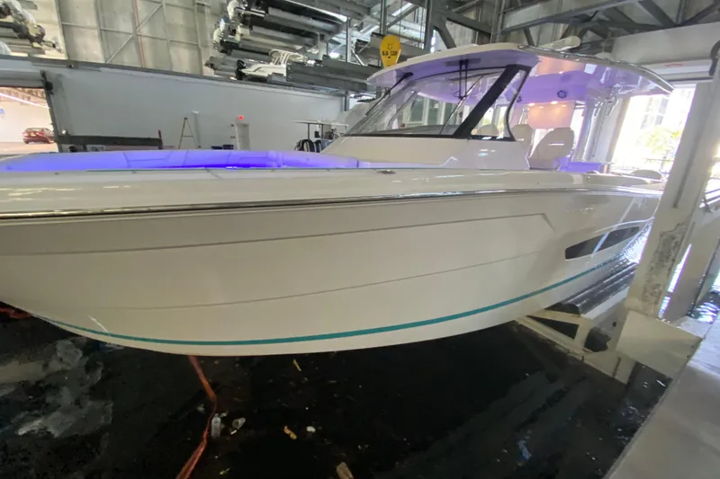 Slide: The Image of 2021 Regal 38 SAV boat in indoor storage with blue accent lighting. - 8