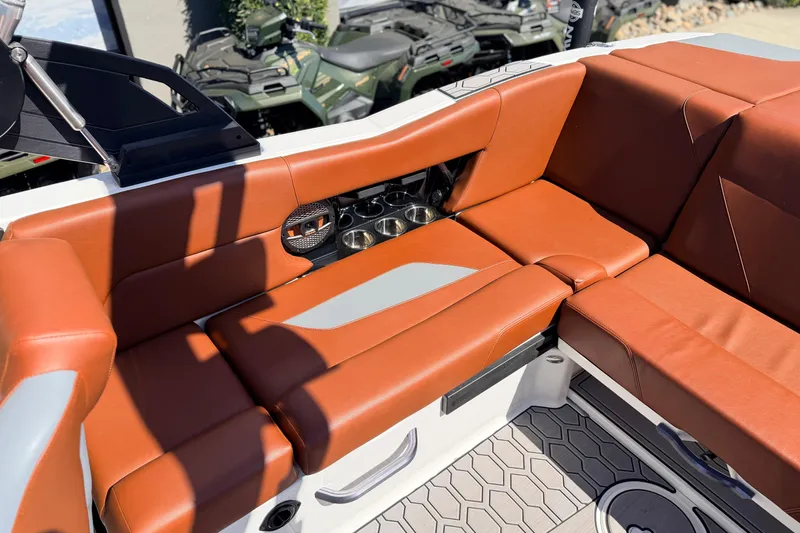 Slide: The Image of 2023 MasterCraft NXT23 boat interior with brown seating and cup holders. - 11