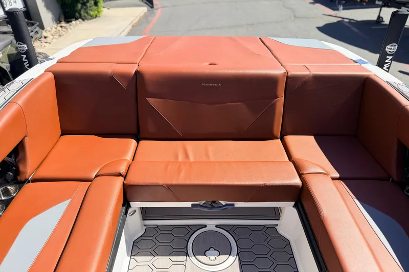 Slide: The Image of 2023 MasterCraft NXT23 boat interior with brown leather seating and hexagonal floor design. - 12