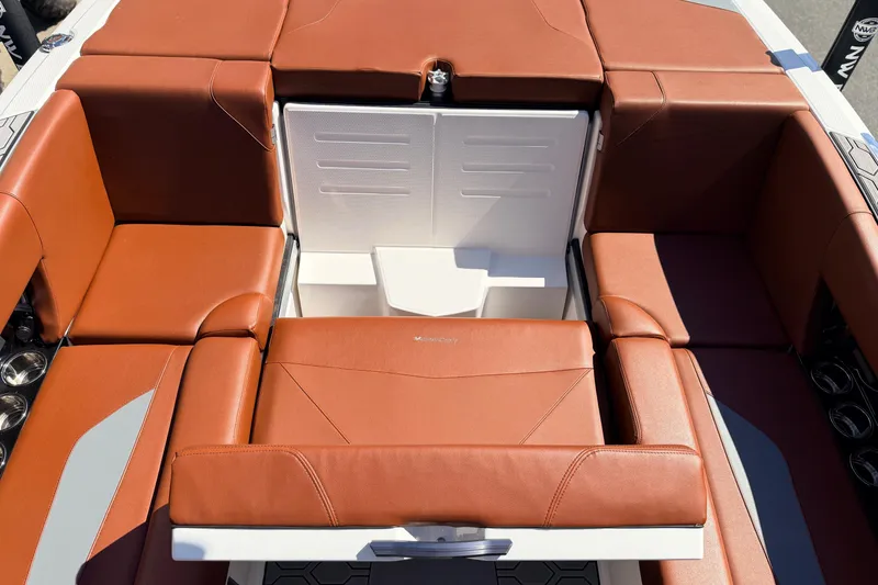 Slide: The Image of 2023 MasterCraft NXT23 boat interior with brown leather seating and storage compartment. - 13