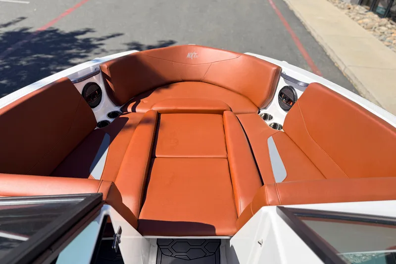Slide: The Image of 2023 MasterCraft NXT23 boat interior with orange seating and cup holders. - 16