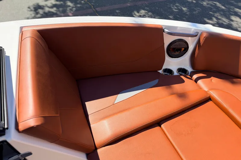 Slide: The Image of 2023 MasterCraft NXT23 boat interior with orange leather seating and speaker system. - 17