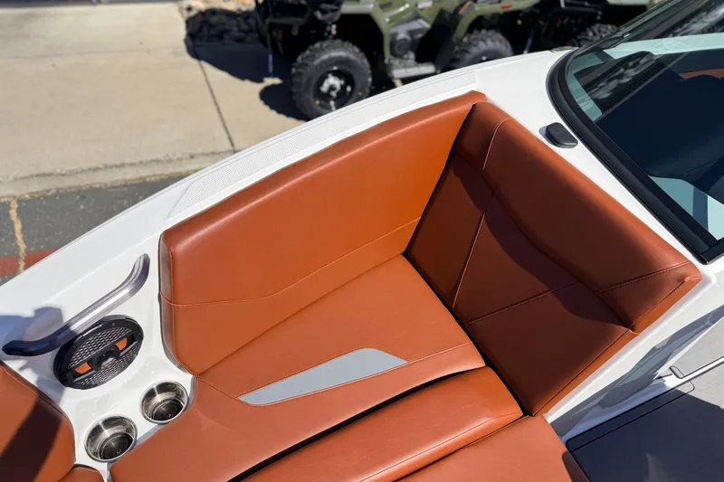 Slide: The Image of 2023 MasterCraft NXT23 boat interior with brown leather seating and cup holders. - 19